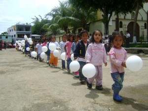 Niños portando globos blancos en señal de paz participaron en desfile. 